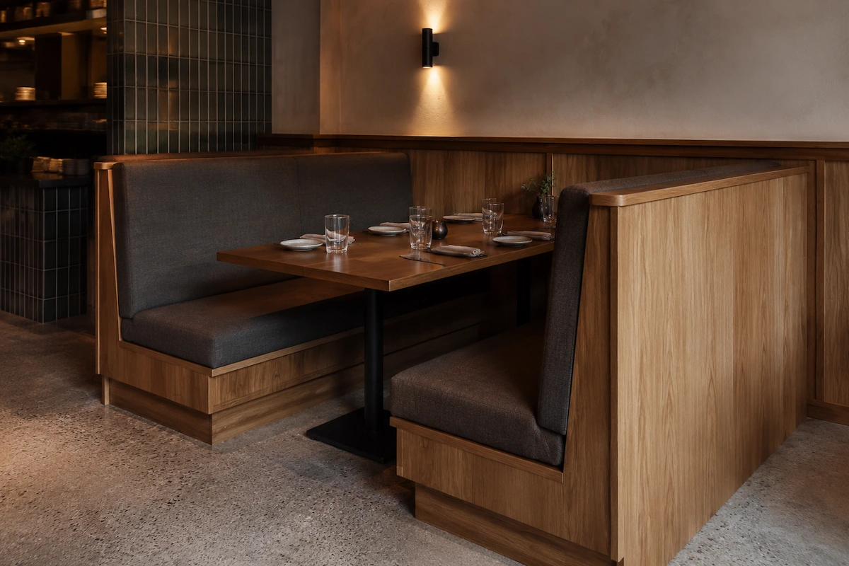 Custom banquette booth seating joinery Melbourne restaurant by Northside Joinery, timber frame booth configuration with warm dining lighting