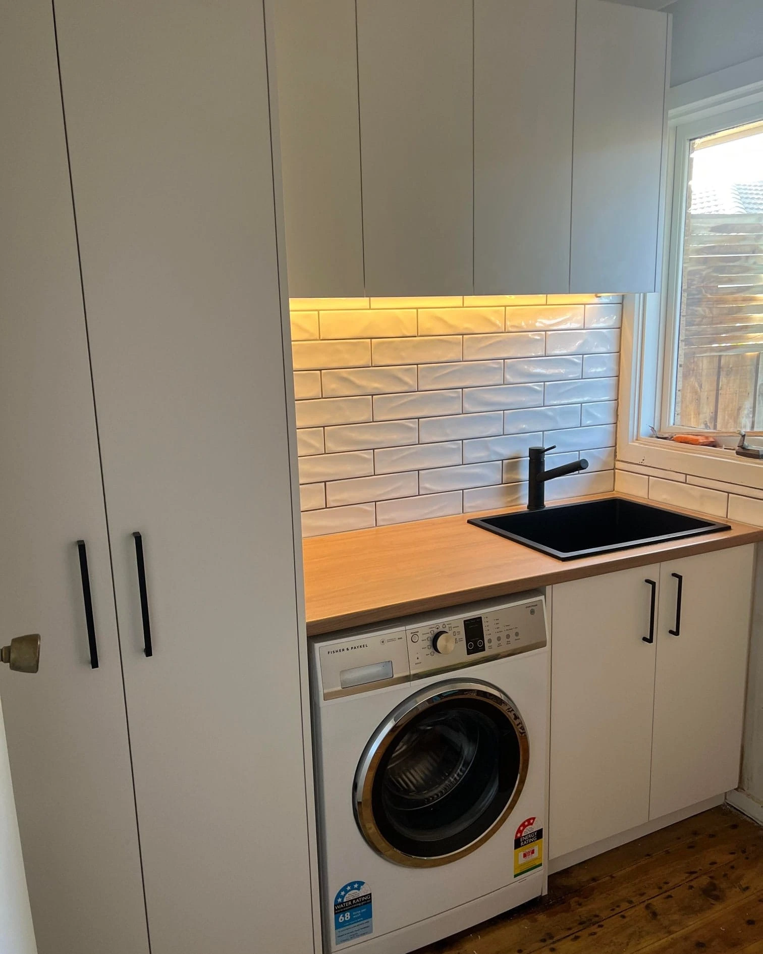 Custom laundry renovation Macleod Melbourne by Northside Joinery, melamine doors with laminate benchtop and LED strip lighting