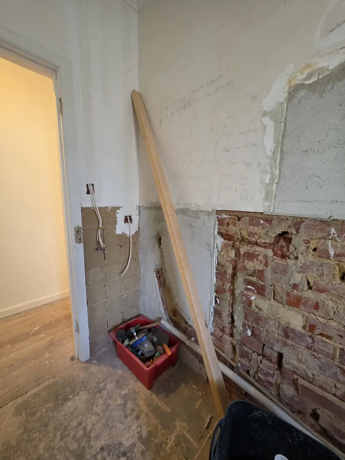 Bathroom rough in plumbing in an East Melbourne apartment with vanity dimensions marked on the wall before custom vanity installation by Northside Joinery Melbourne