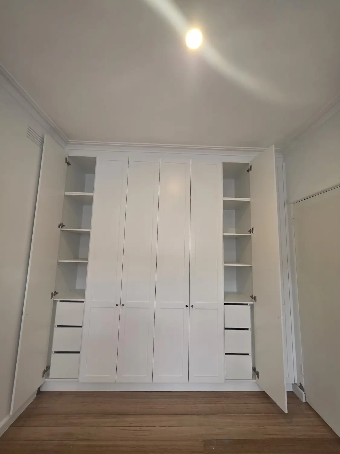 Built in shaker wardrobe in East Melbourne with doors open showing adjustable shelving and soft close storage drawers by Northside Joinery Melbourne