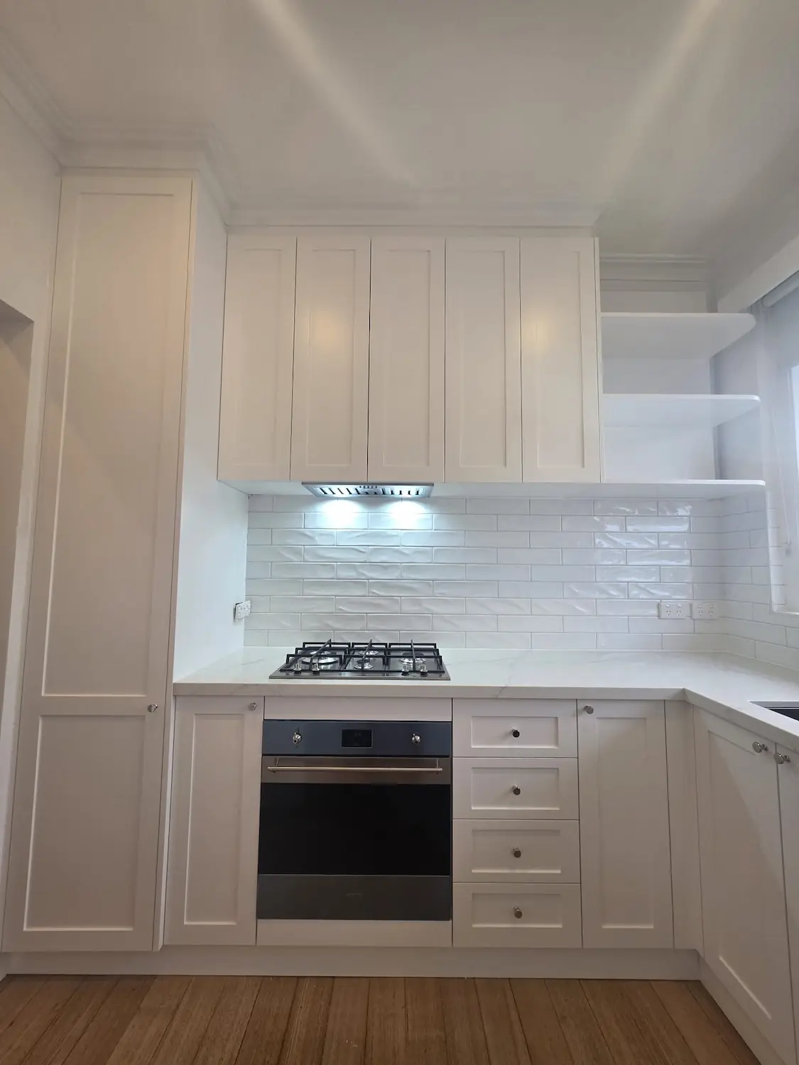 Custom kitchen in East Melbourne with two pack Lexicon Quarter shaker cabinetry, gas cooktop and AC Stone Allure Blue benchtop by Northside Joinery Melbourne
