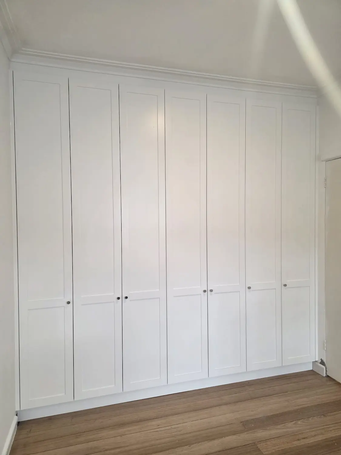 Floor to ceiling shaker built in wardrobe in an East Melbourne bedroom scribed up to the original cornice by Northside Joinery Melbourne