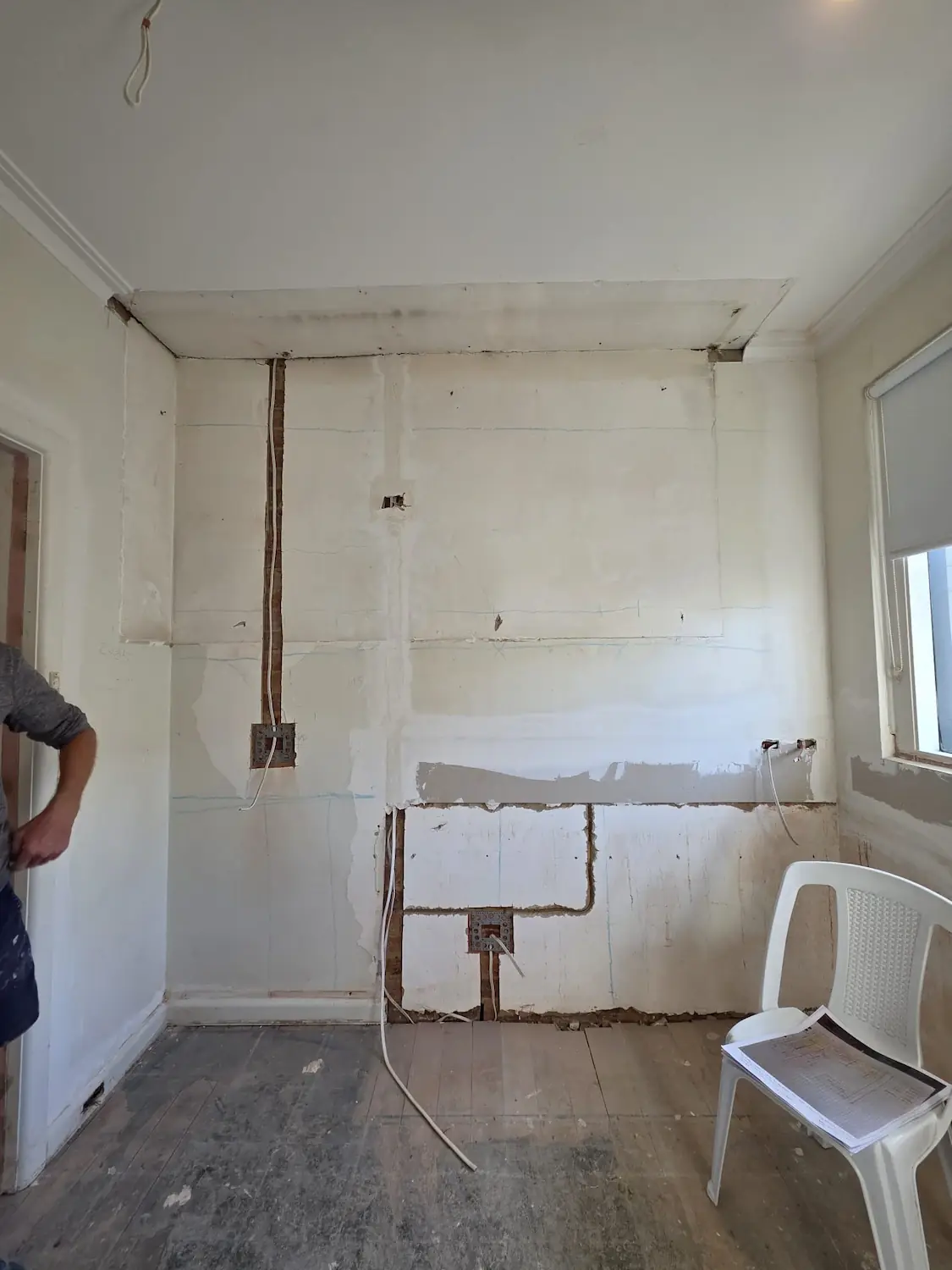 Kitchen wall strip out in East Melbourne apartment showing electrical rough in conduit chased into solid brick before joinery installation by Northside Joinery Melbourne